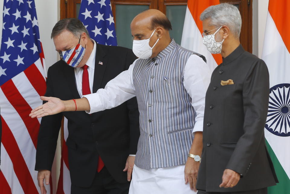 Indian Defence Minister Rajnath Singh, center, gestures towards U.S. Secretary of State Mike Pompeo, left, with Indian Foreign Minister Subrahmanyam Jaishankar, right, standing beside him, ahead of their meeting at Hyderabad House in New Delhi, India, Tuesday, Oct. 27, 2020. In talks on Tuesday with their Indian counterparts, Pompeo and Esper are to sign an agreement expanding military satellite information sharing and highlight strategic cooperation between Washington and New Delhi with an eye toward countering China. (Adnan Abidi/Pool via AP)