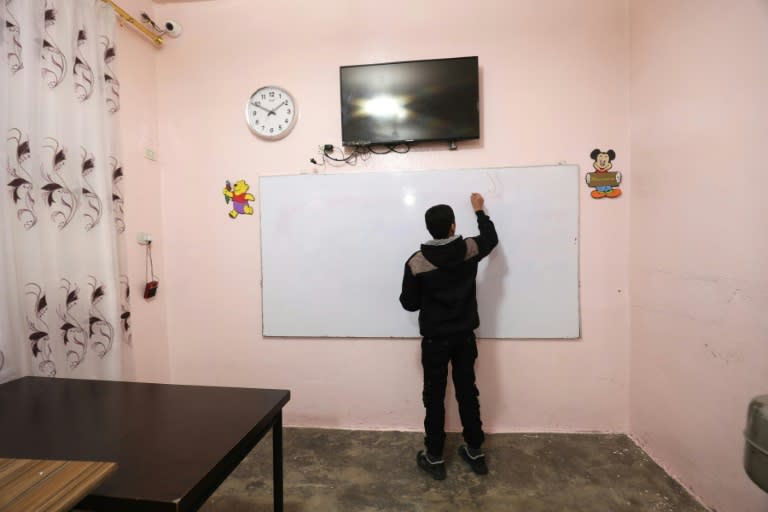 A boy writes on a board at the Hori rehabilitation centre in Tal Maarouf, in Syria's northeastern Hassekeh province, on February 11, 2018