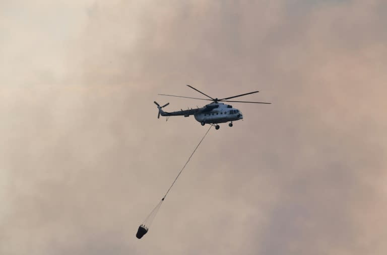 Helicopters scooped up water to douse the flames in fields bordering the Asian Games complex in Palembang