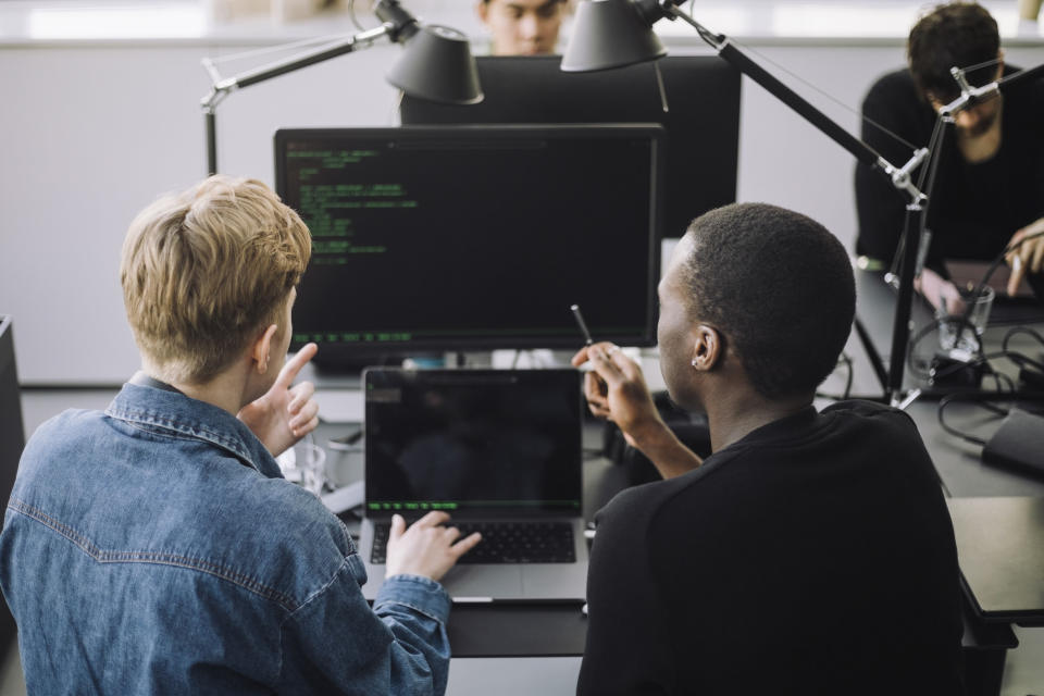 Two men behind a computer screen