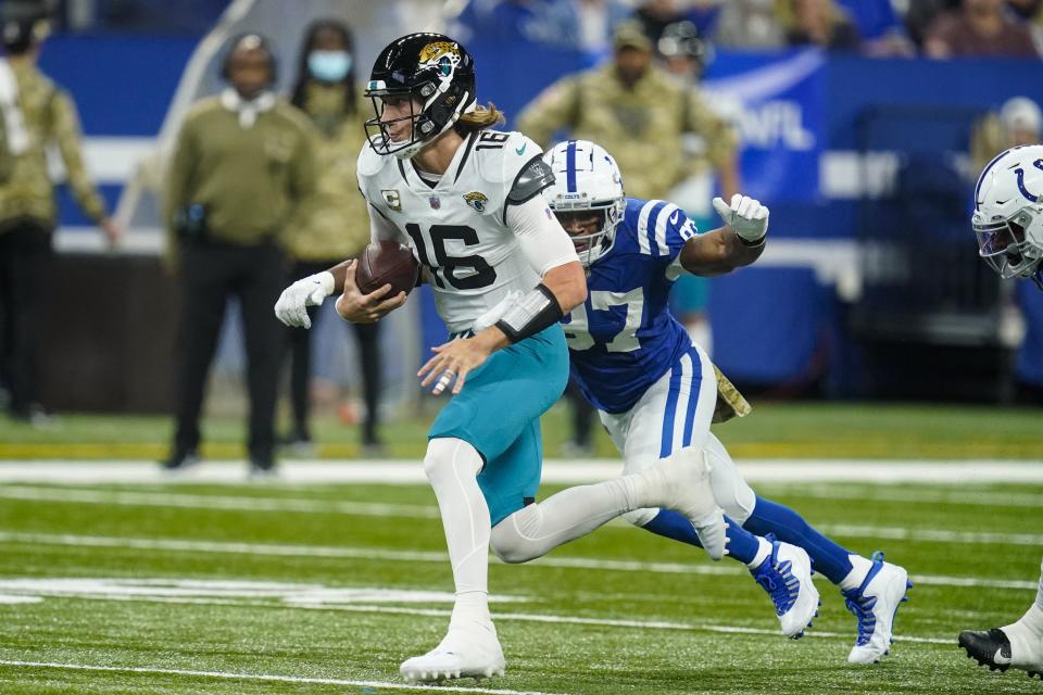 Jacksonville Jaguars quarterback Trevor Lawrence (16) is chased by Indianapolis Colts defensive end Al-Quadin Muhammad (97) in Indianapolis, Sunday, Nov. 14, 2021.