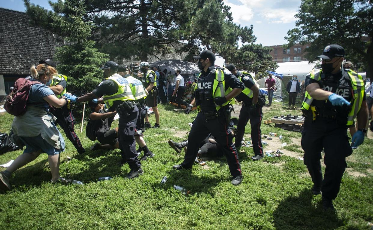 Police remove encampment supporters as they clear the Lamport Stadium Park homeless encampment in Toronto in July 2021. THE CANADIAN PRESS/Chris Young