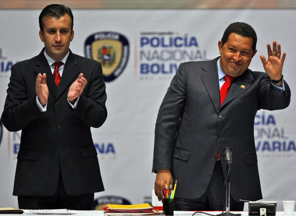 FILE - Venezuela's President Hugo Chavez waves to the audience alongside his Interior Minister Tareck El Aissami at the launching ceremony of the new Bolivarian National Police force in Caracas, Venezuela, Dec. 4, 2009. Venezuela’s government announced on April 9, 2024, the arrest of El Aissami on alleged corruption allegations, one year after his resignation as oil minister. (AP Photo/Fernando Llano)