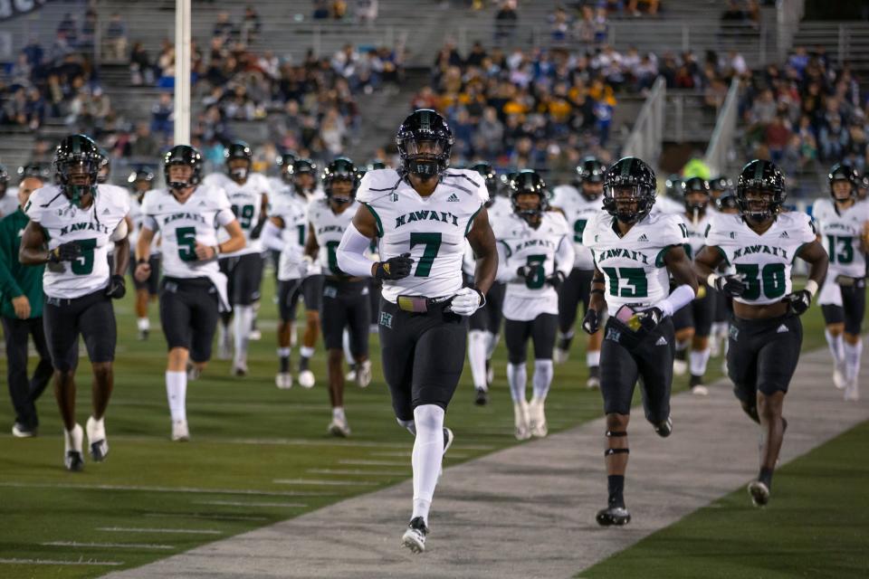 FILE - The Hawaii team takes the field before an NCAA college football game against Nevada in Reno, Nev., Oct. 16, 2021. The Hawaii Bowl was canceled Thursday, Dec. 23, on the eve of the game after Hawaii withdrew because of COVID-19, season-ending injuries and transfers. "We are disappointed our season has to end this way," Hawaii coach Todd Graham said in a statement. "As competitive as we are and as much as we want to play the game, we cannot put the health and safety of our student-athletes at risk." (AP Photo/Tom R. Smedes, File)