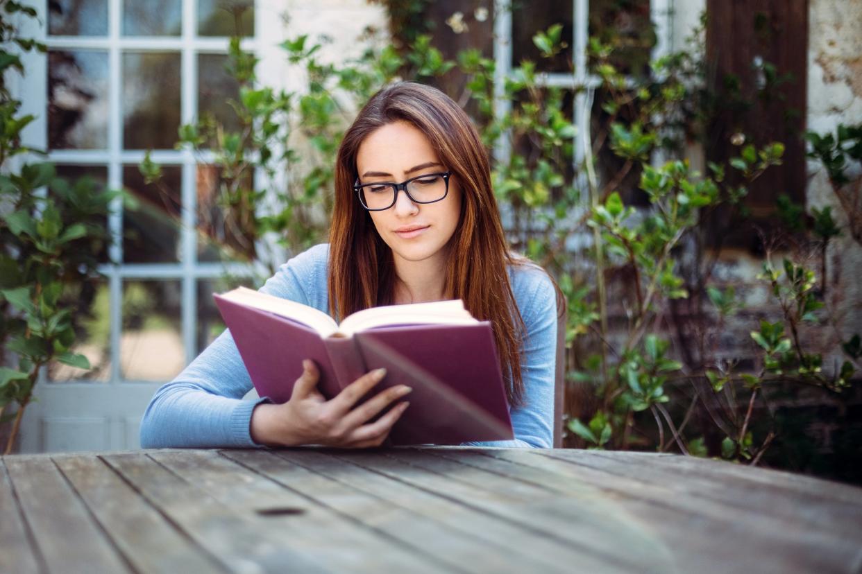 Young woman reading a book outside