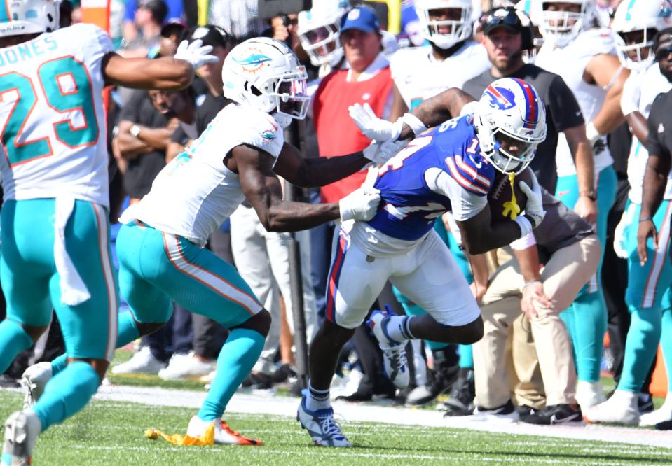 Oct 1, 2023; Orchard Park, New York, USA; Buffalo Bills wide receiver Stefon Diggs (14) breaks a tackle by Miami Dolphins cornerback Kader Kohou (4) to score a touchdown  in the second quarter at Highmark Stadium. Mandatory Credit: Mark Konezny-USA TODAY Sports