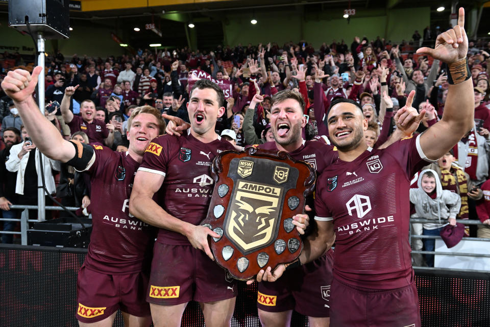 Tom Dearden, Corey Oates, Jai Arrow and Valentine Holmes celebrate with the State of Origin shield.