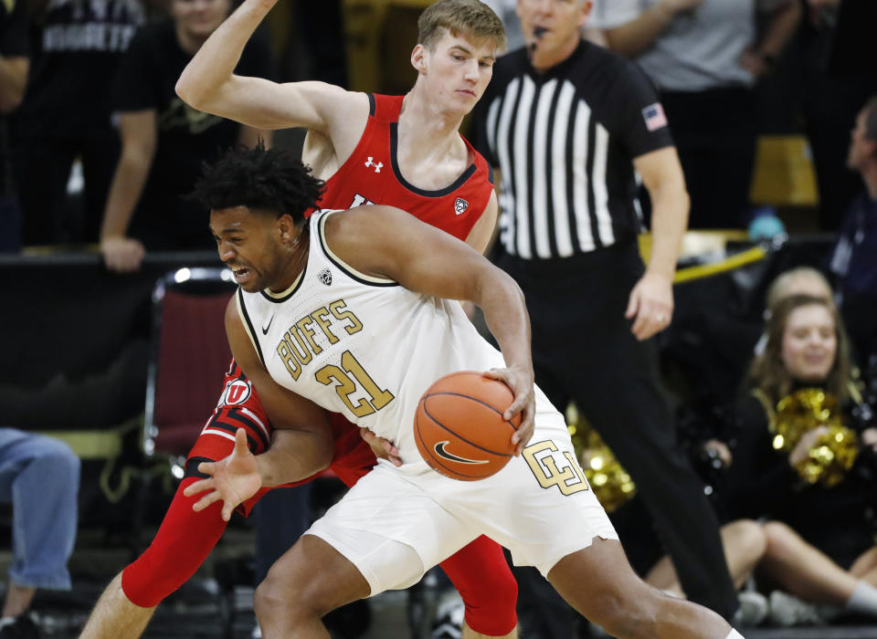 Colorado forward Evan Battey, front, drives to the basket as Utah center Branden Carlson defends in the first half of an NCAA college basketball game Sunday, Jan. 12, 2020, in Boulder, Colo. (AP Photo/David Zalubowski)