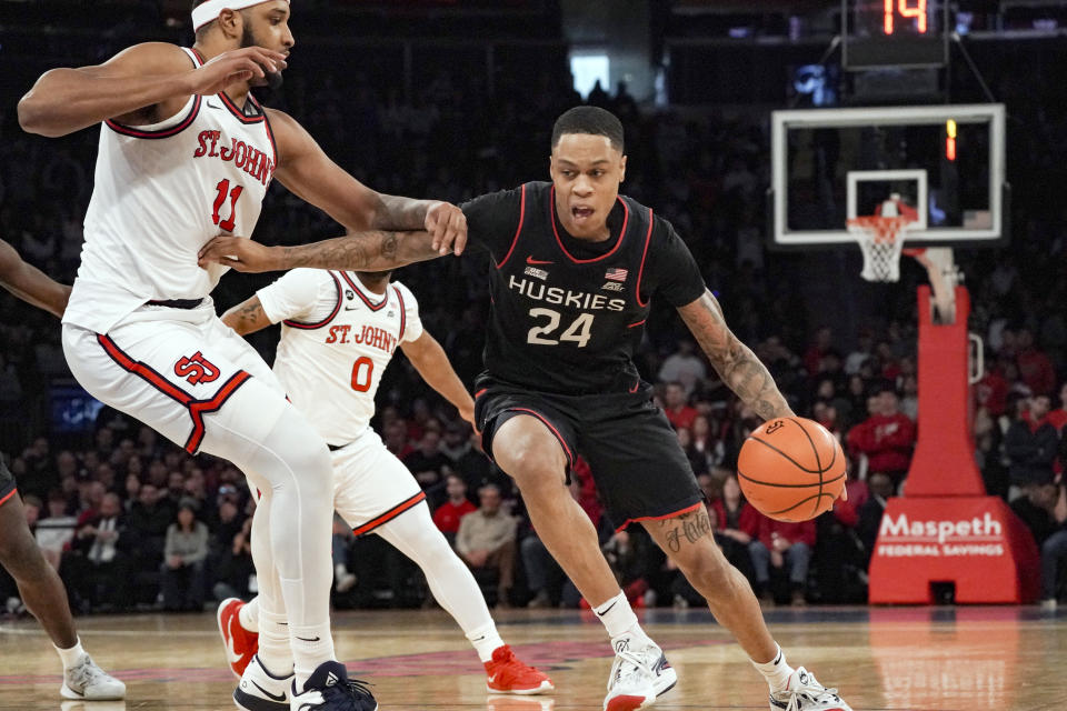 Connecticut guard Jordan Hawkins, right, drives to the basket against St. John's center Joel Soriano, during NCAA basketball game, Saturday Feb. 25, 2023, in New York. (AP Photo/Bebeto Matthews)