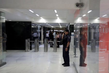 A police officer stands guard as he speaks on his cell phone during a security operation after armed robbers stole gold coins worth more than $2 million, outside Casa de Moneda in Mexico City