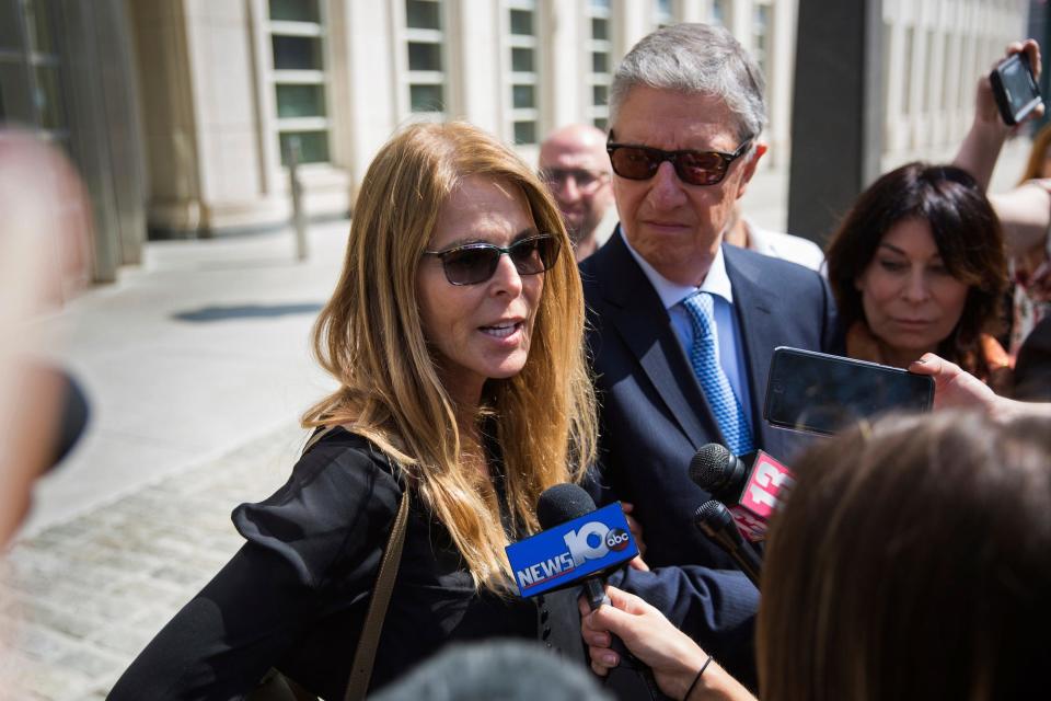 Actress Catherine Oxenberg, left, with Stanley Zareff and Toni Natalie, talks to the press following the arraignment of NXIVM leader Keith Raniere in federal court on Friday, April 13, 2018, in New York. 