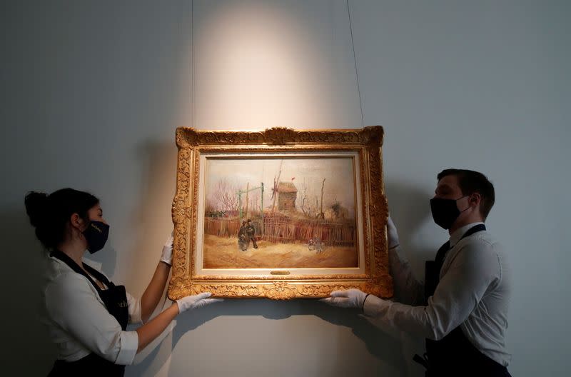 Sotheby's Paris employees pose with the painting "Scene de rue a Montmartre" by Dutch painter Vincent Van Gogh