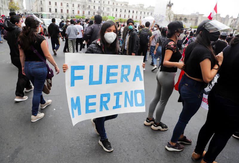 A woman carries a sign reading "Merino out" after Peru's interim President Manuel Merino was sworn in following the removal of President Martin Vizcarra, during protests in Lima