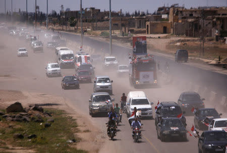 People celebrate the re-opening of the road between Homs and Hama in Talbisi, Syria, June 6, 2018. REUTERS/Omar Sanadiki