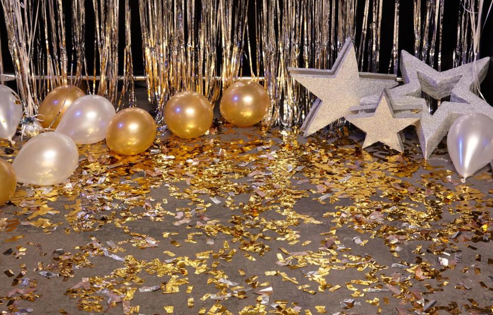golden festive background with balloons, stars and confetti illuminated by colored lanterns