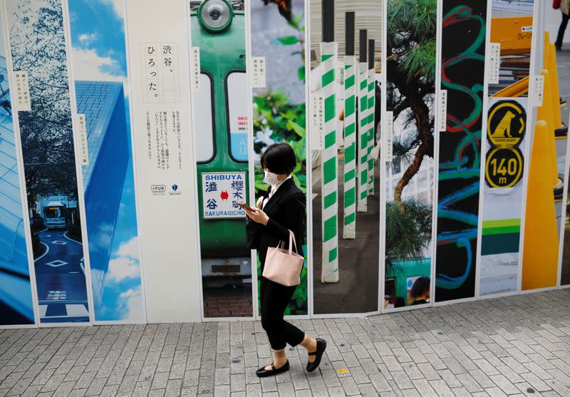 A passerby wearing a protective face mask walks on the street as the spread of the coronavirus disease (COVID-19) continues, in Tokyo