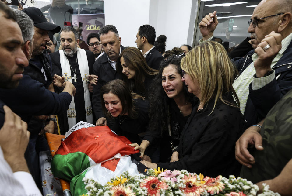 FILE - Colleagues and friends react as the Palestinian flag-draped body of veteran Al-Jazeera journalist Shireen Abu Akleh is brought to the news channel's office in the West Bank city of Ramallah, May 11, 2022. Israel's decision to absolve itself of responsibility for the shooting death of Abu Akleh drew criticism from international media on Thursday, Sept. 8, 2022, marking a further deterioration of relations between the military and reporters covering the conflict. The military said that neither the soldier nor commanders would face any punishment. (Abbas Momani/Pool via AP, File)