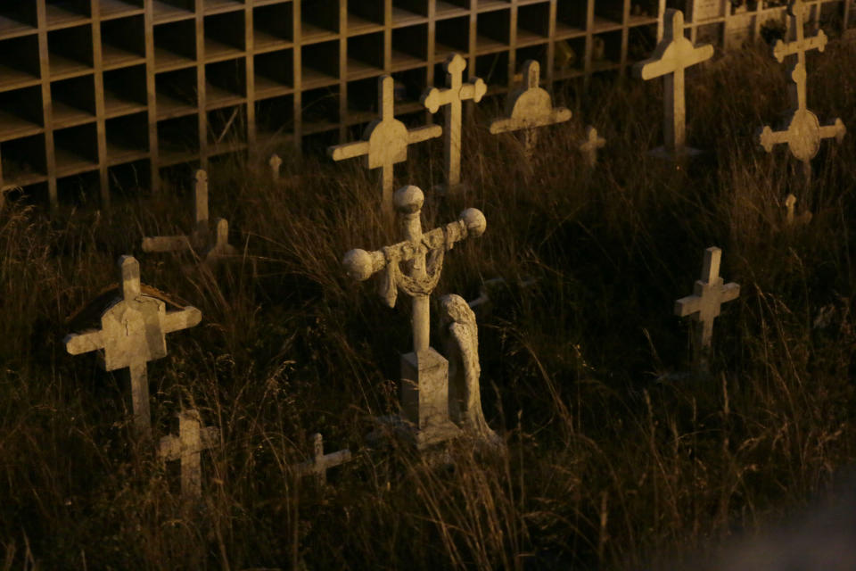 Crosses stand on El Tejar cemetery's potters field in Quito, Ecuador, Wednesday, Sept. 11, 2019. Many tourists said they found the night visit to the cemetery to be a nearly meditative experience. (AP Photo/Dolores Ochoa)