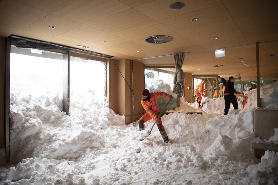 Varias personas retiran el viernes 11 de enero de 2019 la nieve que se metió el día anterior en el hotel Saentis debido a una avalancha en Schwaegalp, Suiza. (Gian Ehrenzeller/Keystone vía AP)