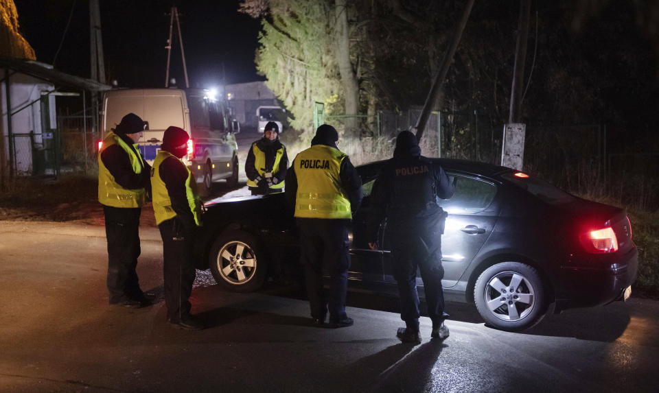 Police officers gather outside a grain depot in Przewodow, eastern Poland, on Tuesday Nov. 15, 2022 where the Polish Foreign Ministry said that a Russian-made missile fell and killed two people. The ministry said Foreign Minister Zbigniew Rau summoned the Russian ambassador and "demanded immediate detailed explanations." (AP Photo)