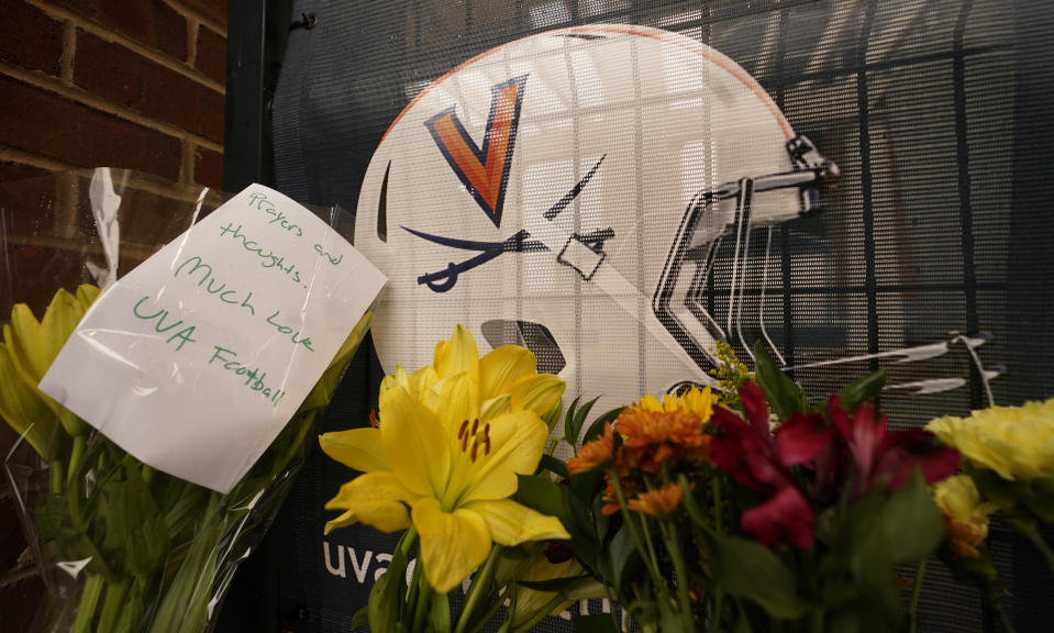 Memorial flowers and notes line walkway at Scott Stadium after three football players were killed in a shooting on the grounds of the University of Virginia Tuesday Nov. 15, 2022, in Charlottesville. Va. (AP Photo/Steve Helber)