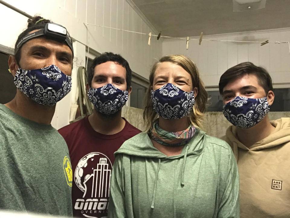 In this Nov. 4, 2020, photo provided by Matt Saunter, Saunter, left, Matt Butschek II, second from left, Naomi Worcester and Charlie Thomas, right, wear masks after arriving in Honolulu from an 8-month expedition to Kure Atoll in the Northwestern Hawaiian Islands. Cut off from the rest of the planet since February, they are back, re-emerging into a society changed by the coronavirus outbreak. (Matt Saunter/Hawaii Department of Land and Natural Resources via AP)