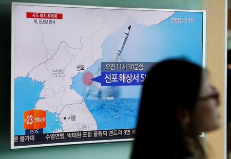 A passenger walks past a TV screen at a railway station in Seoul, South Korea, broadcasting a news report on North Korea's submarine-launched ballistic missile fired from North Korea's east coast port of Sinpo July 9, 2016. REUTERS/Kim Hong-Ji