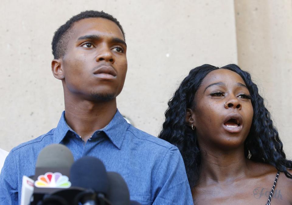 Iesha Harper, right, answers a question during a news conference as she is joined by her fiancee Dravon Ames, left, at Phoenix City Hall, Monday, June 17, 2019, in Phoenix. Ames and his pregnant fiancée, Harper, who had guns aimed at them by Phoenix police during a response to a shoplifting report say they don't accept the apologies of the city's police chief and mayor and want the officers involved to be fired.(AP Photo/Ross D. Franklin)