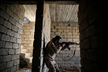 A member of the Iraqi Army fires during clashes with Islamic State militants at the south of Mosul, Iraq December 12, 2016. REUTERS/Ammar Awad