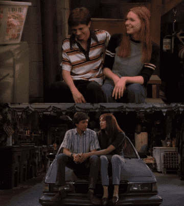 eric and donna playfully pushing each other's heads in that 70s show and that 90s show