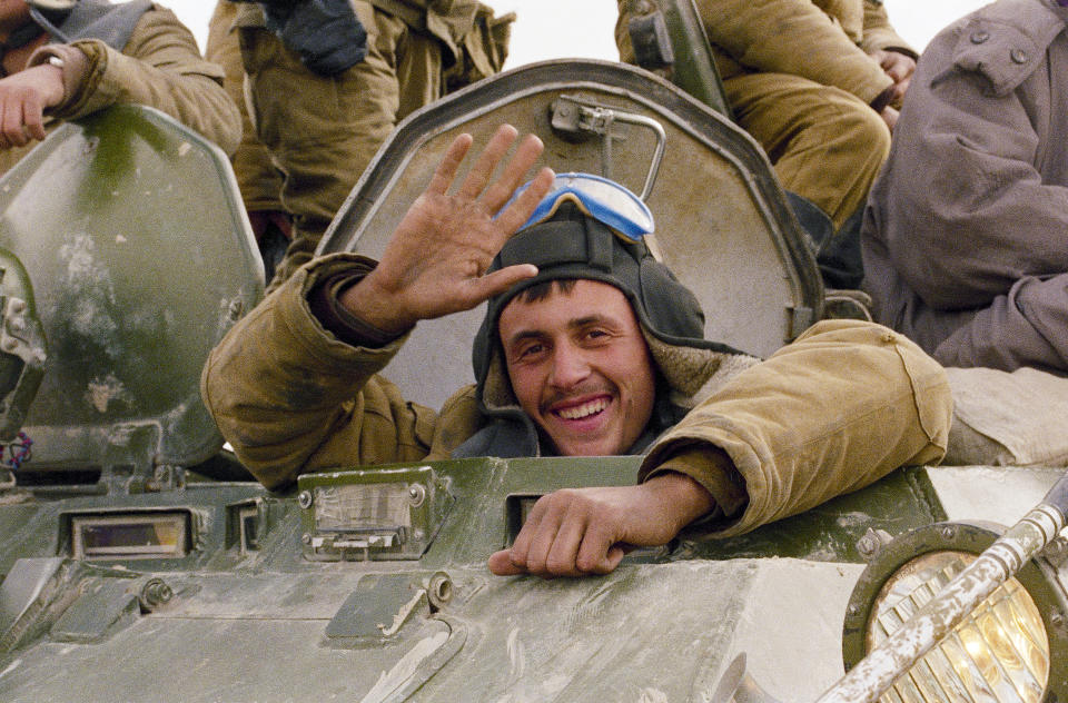 FILE - A smile and a wave from a Soviet soldier, as his armoured convoy makes its way back to the Soviet Union along a north Afghanistan highway, Feb. 7, 1989. Despite Afghanistan's reputation as "the graveyard of empires," the Soviet Union sent in troops in 1979, quickly assassinating the country's leader and moving to install a compliant successor. More than 14,000 Soviet Army troops died in the conflict that seriously eroded the image of Soviet military superiority. (AP Photo/Boris Yurchenko, File)