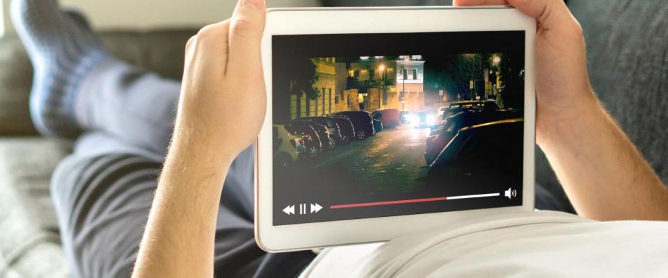 Man watching film on his tablet using Netflix or some other video streaming service