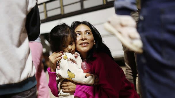 PHOTO: Peruvian immigrant family members, who are seeking asylum in the United States, embrace as they wait to board a bus during processing by U.S. Border Patrol agents after crossing into Arizona from Mexico on May 11, 2023 in Yuma, Ariz. (Mario Tama/Getty Images)