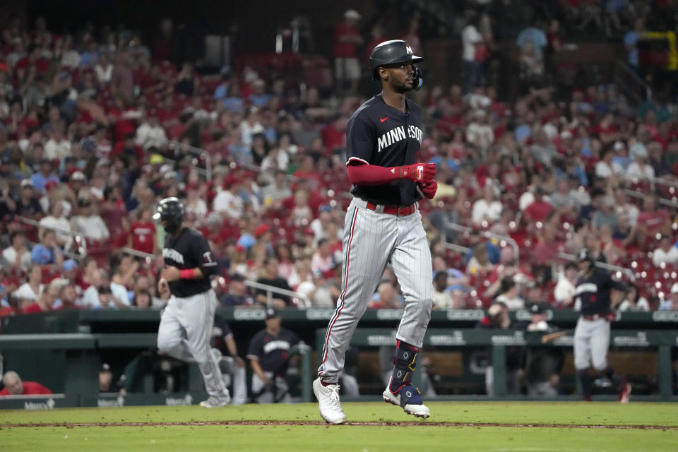 Minnesota Twins' Michael A. Taylor, right, heads to first on a bases-loaded walk as teammate Donovan Solano, left, jogs in to score during the sixth inning of a baseball game aSt. Louis Cardinals Thursday, Aug. 3, 2023, in St. Louis. (AP Photo/Jeff Roberson)
