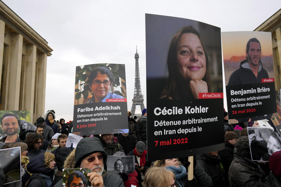 FILE - People hold portraits of French detainees in Iran Fariba Adelkhah, left, Cecile Kohler, center, and Benjamin Briere, right, during a protest in Paris, on Jan. 28, 2023. Paris' political sciences institute Sciences Po announced on Wednesday Oct. 18, 2023 that French-Iranian academic Fariba Adelkhah, who had previously been for years detained in Iran, has returned to France. (AP Photo/Thibault Camus, File)