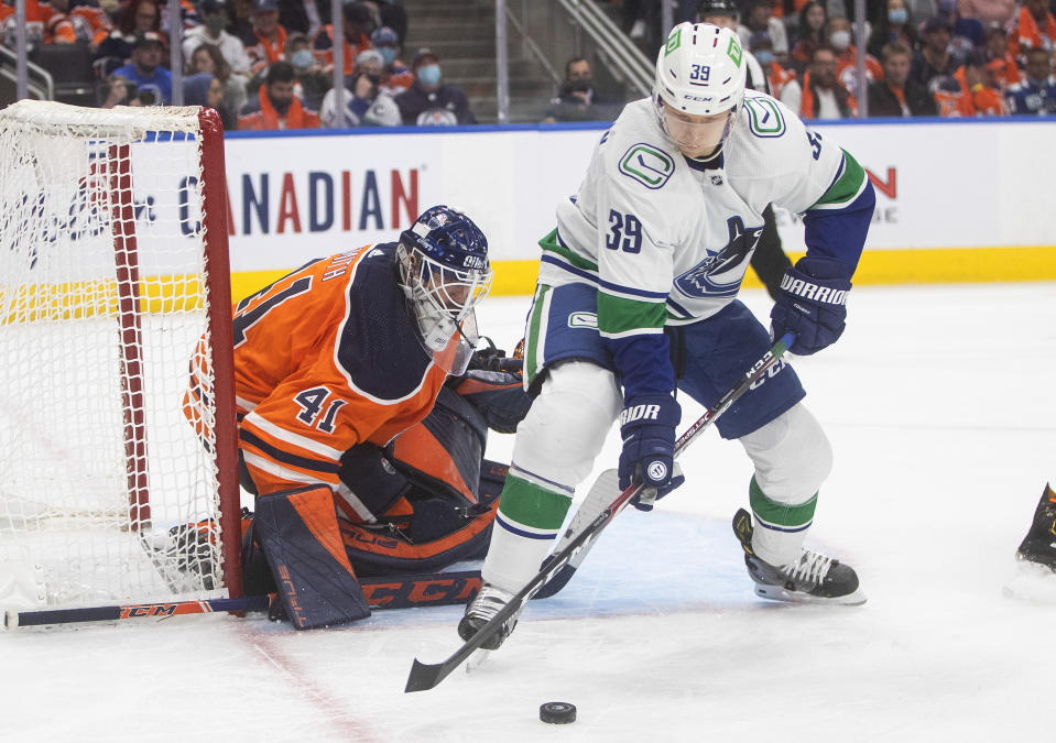 Vancouver Canucks' Alex Chiasson (39) picks up a rebound from Edmonton Oilers goalie Mike Smith (41) during the third period of an NHL hockey game Wednesday, Oct. 13, 2021, in Edmonton, Alberta. (Jason Franson/The Canadian Press via AP)