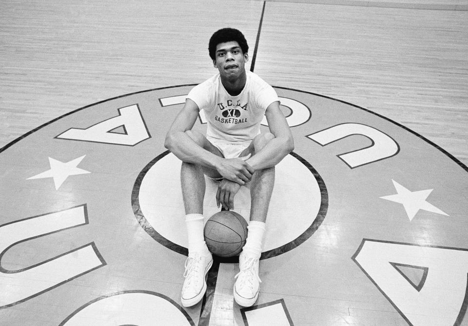 FILE - Lew Alcindor (now Kareem Abdul-Jabbar) sits at center court in UCLA's Pauley Pavilion, Feb. 27, 1969. (AP Photo)