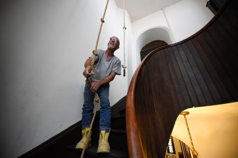 Steeplejack Fred Franklin rings the steeple bell at First Christian Church on Wednesday, Aug. 3, 2022. Franklin was pressure-washing and repainting First Christian Church off Greene Street.
