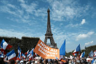 FILE - In this Sept. 4, 2021, file photo, a protester holds a placard reading "No to the health pass" during a demonstration against the COVID-19 health pass in front of the Eiffel Tower, in Paris. Italy and France have seen thousands take the streets in protests of the COVID passes, some of which resulted in clashes with police in Paris. (AP Photo/Thibault Camus, File)