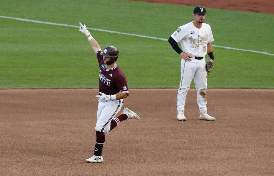 Jun 30, 2021; Omaha, Nebraska, USA;  Mississippi State Bulldogs catcher Logan Tanner (19) gestures after hitting a home run as Vanderbilt Commodores second baseman Parker Noland (25) looks on in the seventh inning at TD Ameritrade Park. Mandatory Credit: Bruce Thorson-USA TODAY Sports