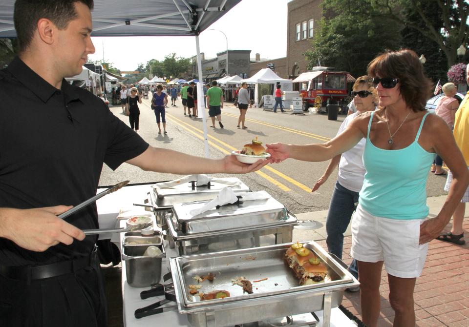 Toma Vulaj serves up a beef brisket slider to guest Diane Fowkes during the annual Taste of Brighton event.