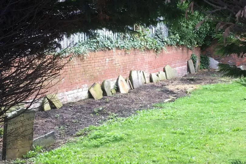 Gravestones have been lined up against one of the boundary walls