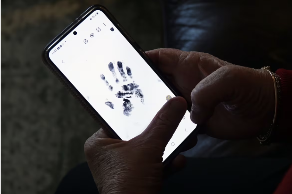 Insley looks at a handprint she asked for as a memento of her son. She said police later used the print to determine the actual identity of the man whose death she'd mourned. (Dan Taekema/CBC)