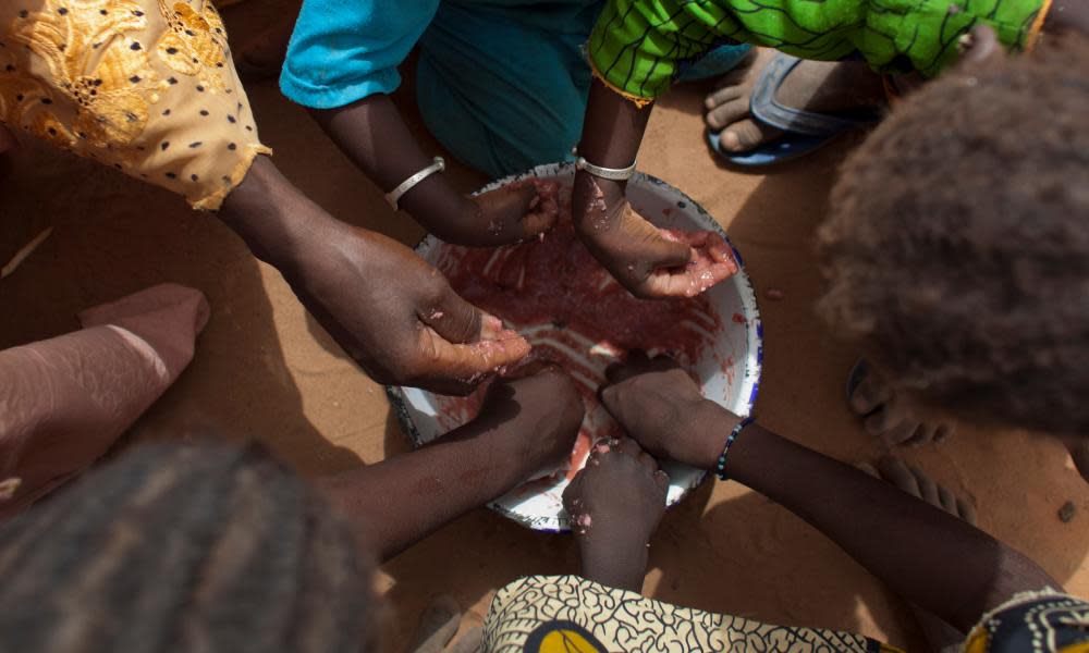 Children share a bowl of porridge in a village in Senegal