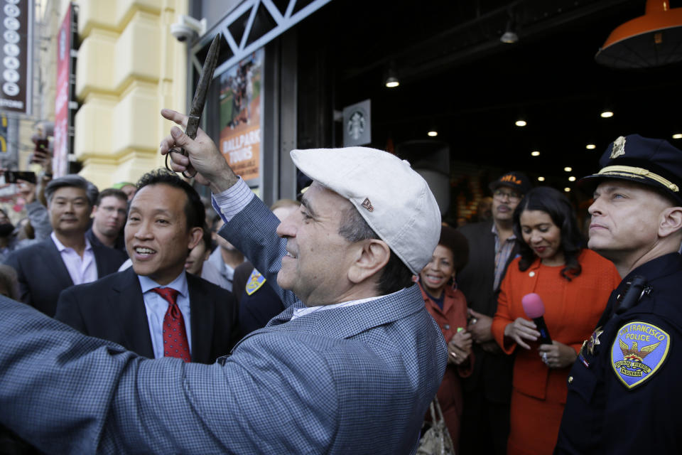 File - In this Nov. 20, 2018, file photo, owner Nick Bovis prepares to cut a ribbon during the opening of Lefty O'Doul's Baseball Ballpark Buffet & Café at Fisherman's Wharf in San Francisco. Looking on are state assemblyman David Chiu, second from left, San Francisco Mayor London Breed, second from right and city public works director Mohammed Nuru, third from right. A top San Francisco official in charge of cleaning up the city's notoriously filthy streets and a champion of adding more portable toilets has been arrested, jail records show. San Francisco Public Works Director Mohammed Nuru was taken into custody Monday, Jan. 27, 2020, along with Nick Bovis, the owner of Lefty O' Doul's, a longtime sports bar popular with tourists. Records say only that the men were arrested for felony safekeeping, which typically indicates federal charges. (AP Photo/Eric Risberg)