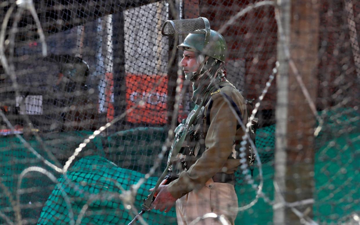 An Indian policeman stands guard outside a bunker alongside a road in Srinagar - REUTERS