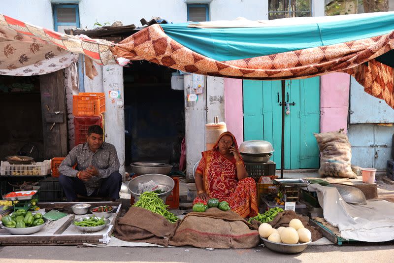 FILE PHOTO: Kantaben Kishanbhai Parmar waits for customers at her roadside vegetable stall in Ahmedabad