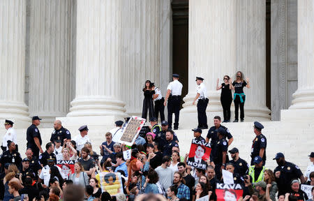 A protester is arrested as police clear the steps of the U.S. Supreme Court building of demonstrators while Judge Brett Kavanaugh is being sworn in as an Associate Justice of the court inside on Capitol Hill in Washington, U.S., October 6, 2018. REUTERS/Jonathan Ernst