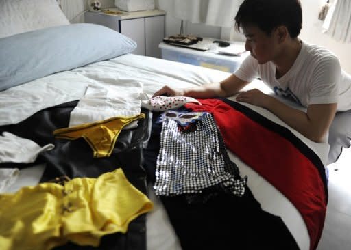 Part-time male stripper Bryan Tan displays with his costumes in his apartment. In a country where public nudity is outlawed, strippers say demand for their services is getting stronger despite deep-seated conservatism in the city-state