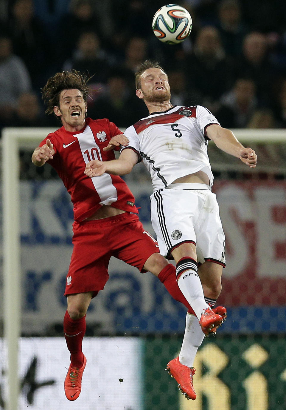 Germany's Shkodran Mustafi, right, and Poland's Ludovic Obraniak, left, challenge for the ball during a friendly soccer match between Germany and Poland in Hamburg, Germany, Tuesday, May 13, 2014. (AP Photo/Michael Sohn)